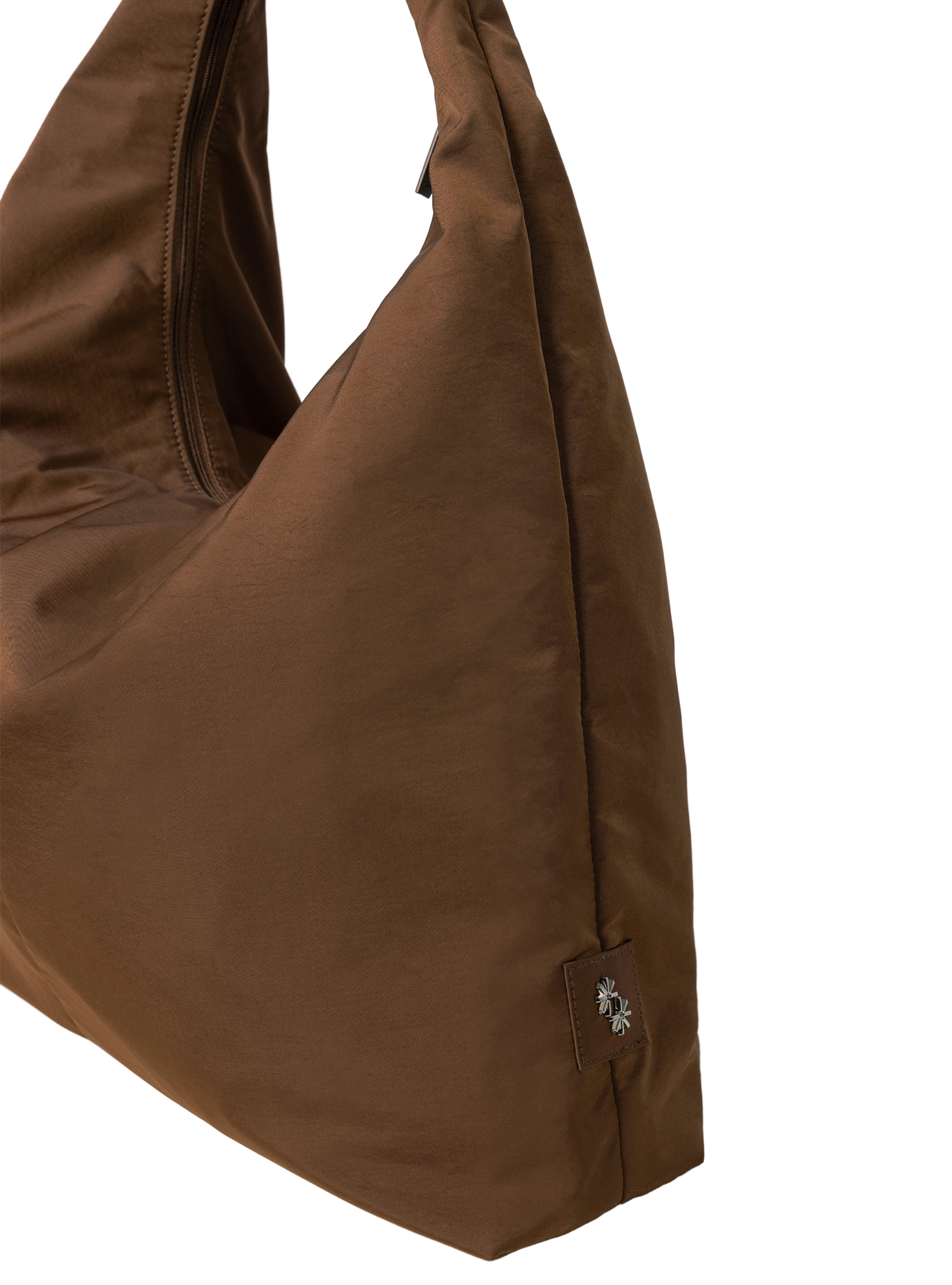 Close-up of the Arc hobo-style bag in chocolate brown nylon, showing metal logo emblem