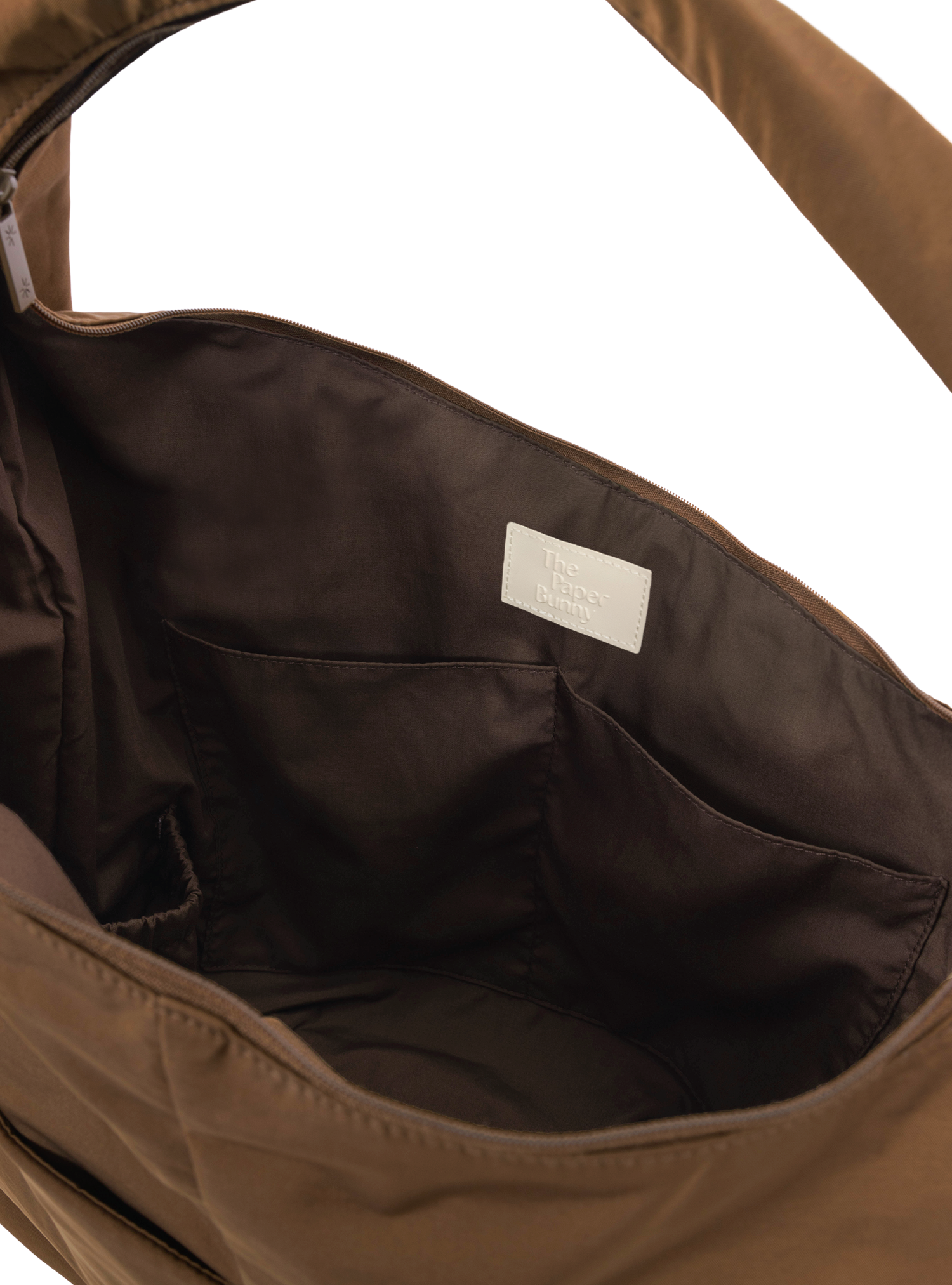 Interior of the Arc hobo-style bag in chocolate brown nylon, with multiple pockets and a bottle holder